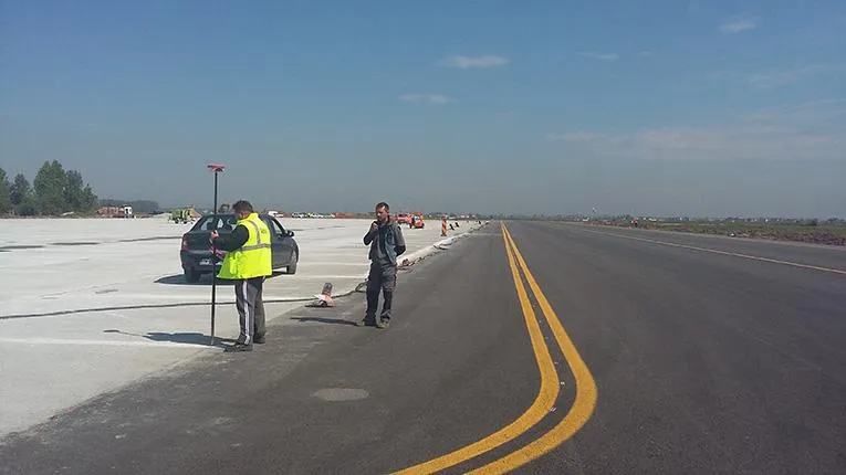 Ingineri PROMETER M&G efectuând măsurători cu GPS pe pista unui aeroport
